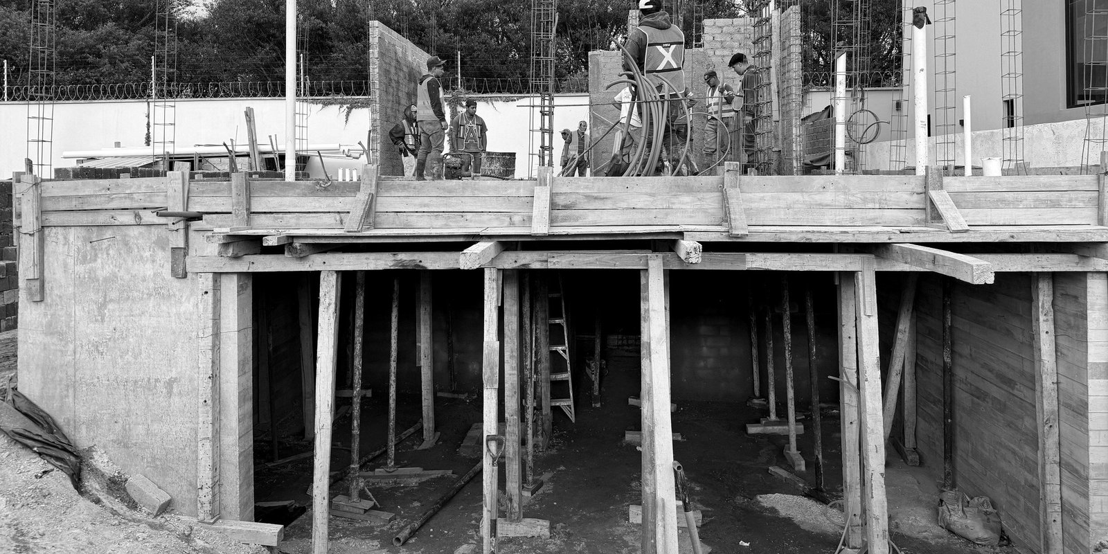 Cimbra de madera apuntalando la losa durante la obra, en blanco y negro. Casa PV.